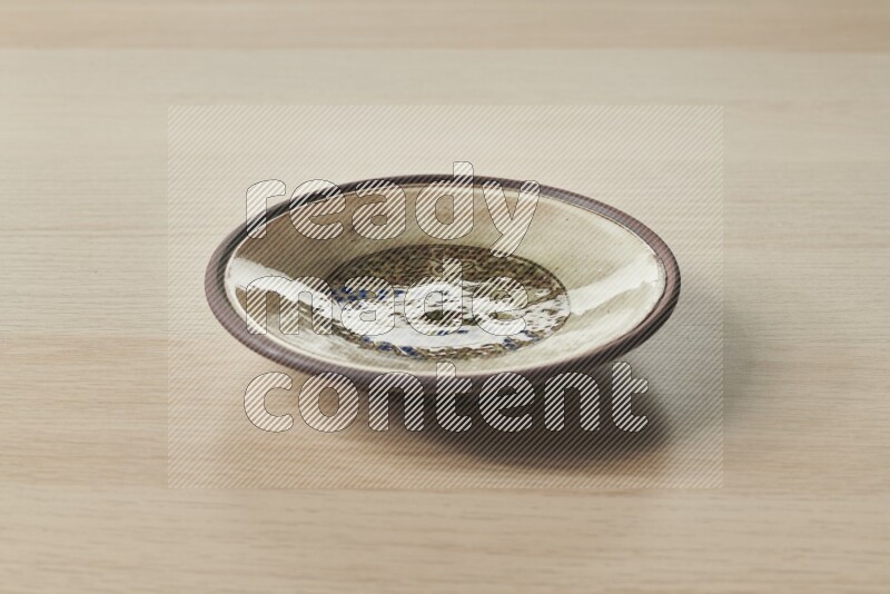 A decorative pottery plate on light wooden background