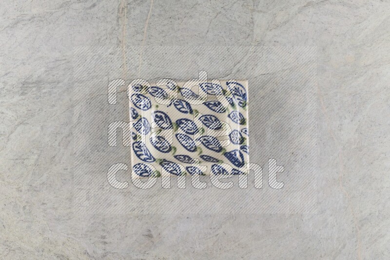A decorative pottery plate on grey marble background