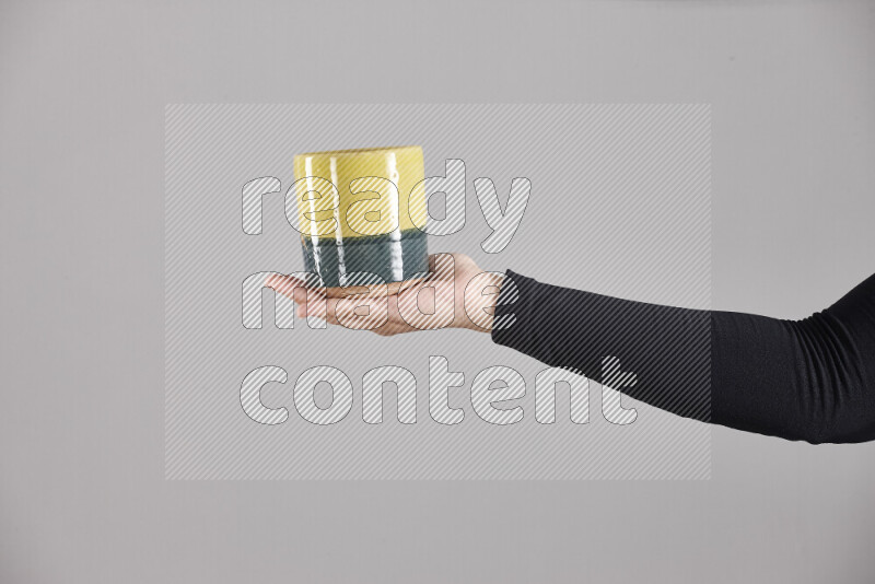 A woman in black abaya holding different pottery essentials in different positions