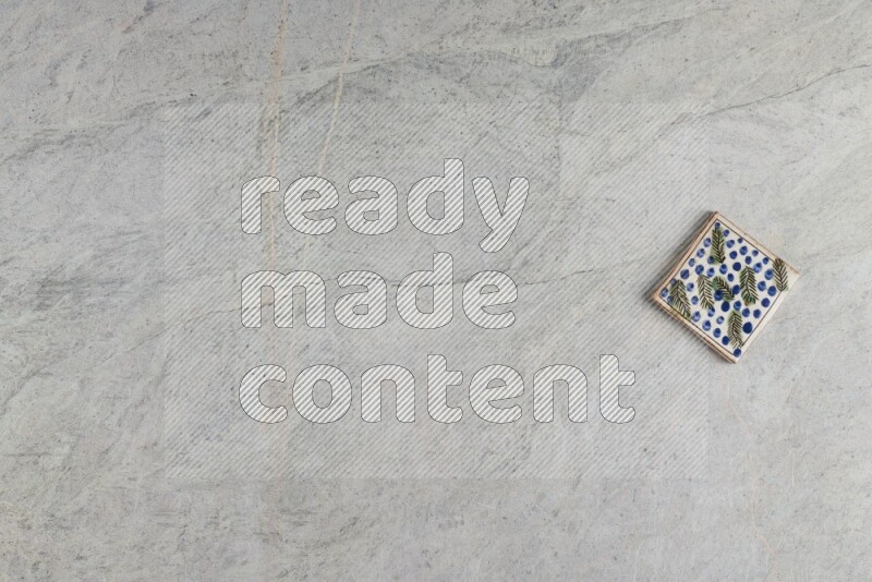A decorative pottery coaster on grey marble background