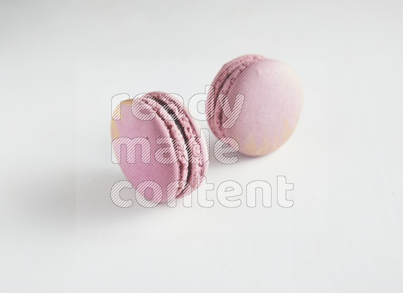 45º Shot of two Purple Strawberry macarons on white background