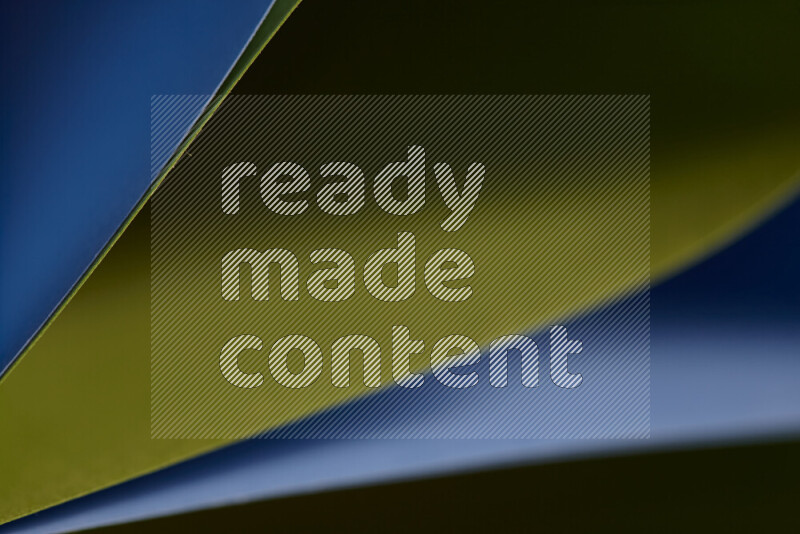 An abstract art showing blue and green paper sheets arranged in an overlapping curves