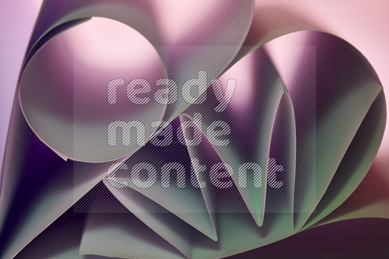 عرض فني لطيات الورق تخلق مزيج من الأشكال الهندسية، مضاءة بإضاءة ناعمة بدرجات اللون الأخضر والارجواني