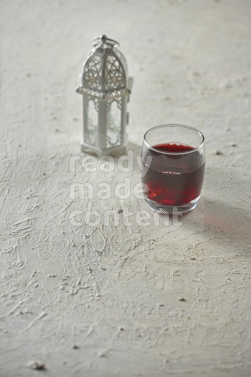 A white lantern with different drinks, dates, nuts, prayer beads and quran on white background