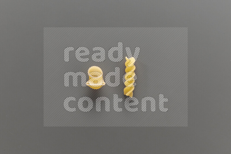 Pipe pasta with other types of pasta on grey background