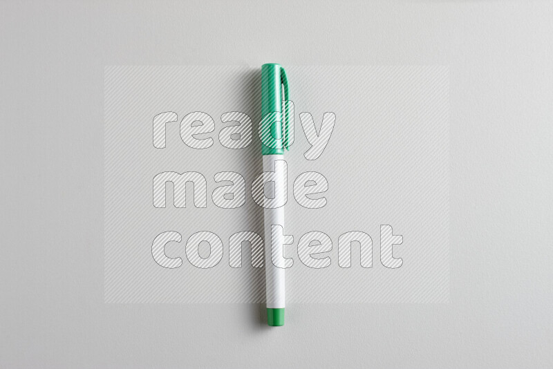 A close-up showing a single coloring pen with a cap on grey background