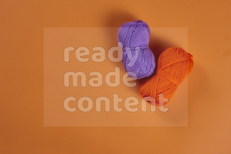 مجموعة من أدوات الخياطة والتفصيل أرجوانية اللون على خلفية برتقالية