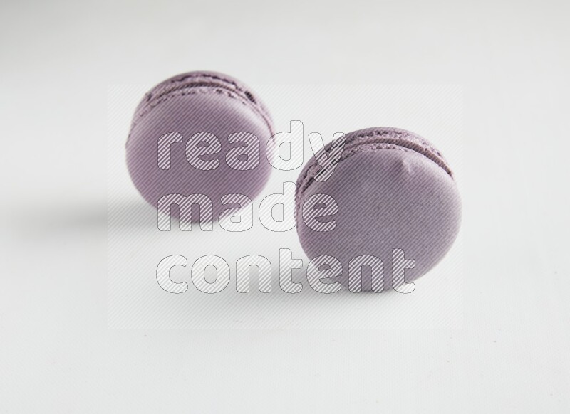 45º Shot of two Purple Blueberry macarons on white background