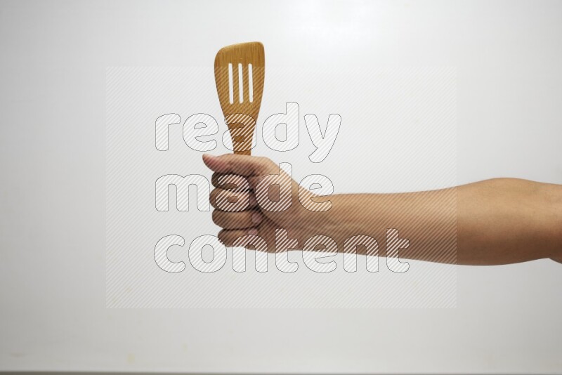 Male Hand Holding Slotted Turner on white background