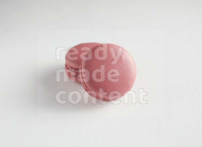 45º Shot of two Pink Raspberry macarons on white background