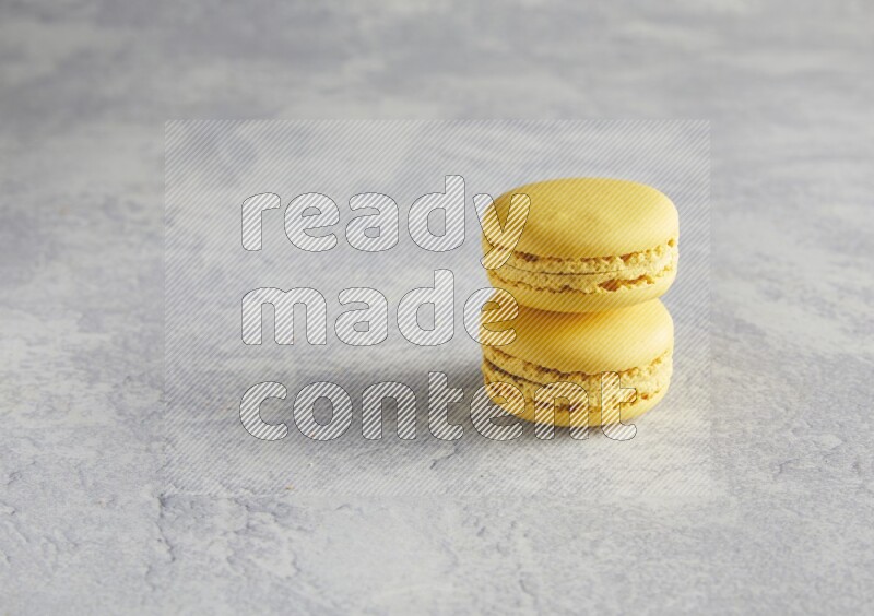 45º Shot of two Yellow Lemon macarons  on white  marble background