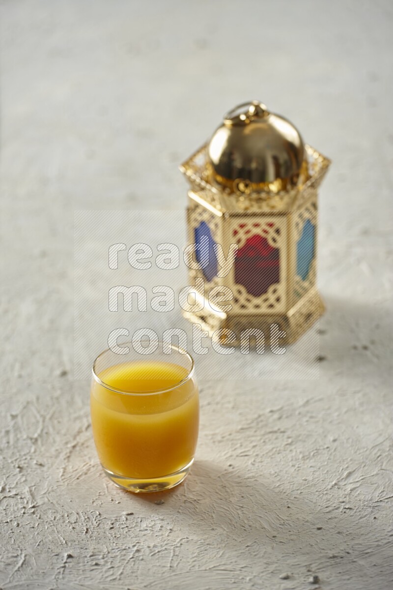 A golden lantern with different drinks, dates, nuts, prayer beads and quran on textured white background