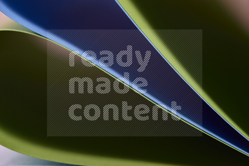 An abstract art showing blue and green paper sheets arranged in an overlapping curves