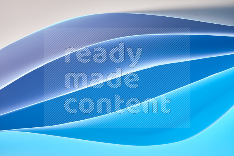 This image showcases an abstract paper art composition with paper curves in blue gradients created by colored light
