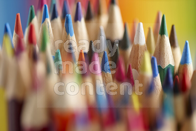 The image captures a close-up of sharpened colored pencils on multicolored background