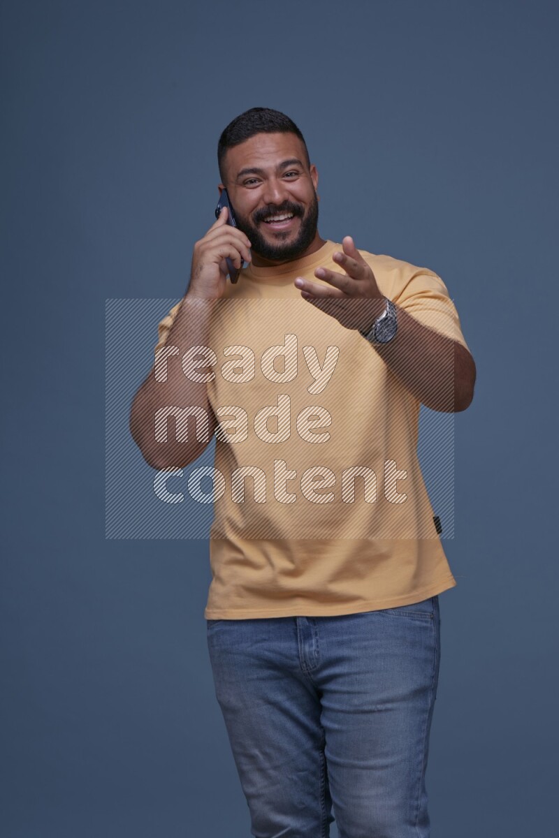 A man Calling on Blue Background wearing Orange T-shirt