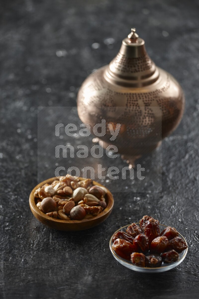 A golden lantern with different drinks, dates, nuts, prayer beads and quran on textured black background