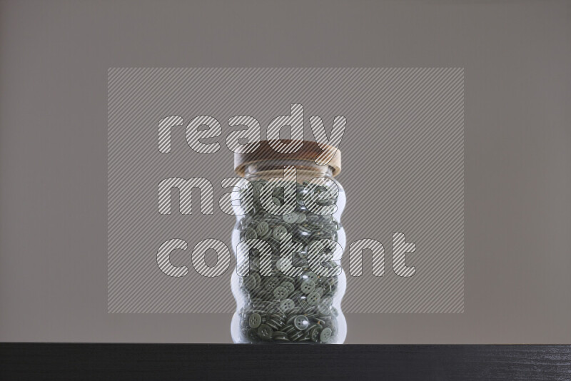 Buttons in a glass jar on black background