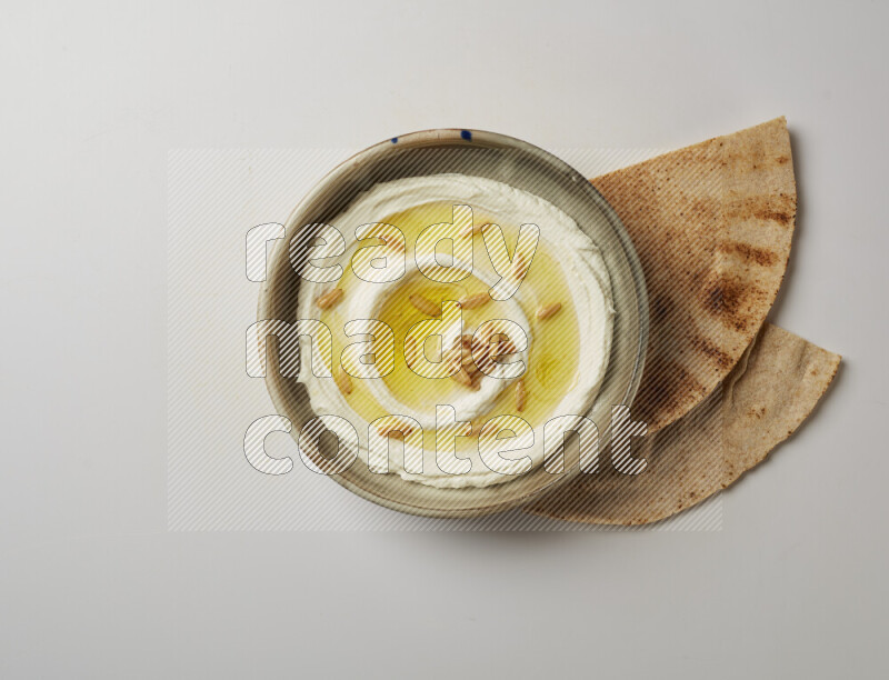 Lebnah garnished with pine nuts in a grey pottery plate on a white background