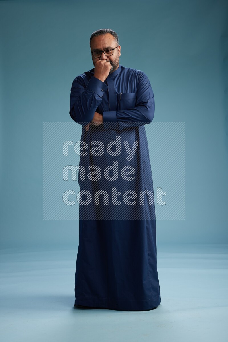 Saudi Man without shimag Standing Interacting with the camera on blue background