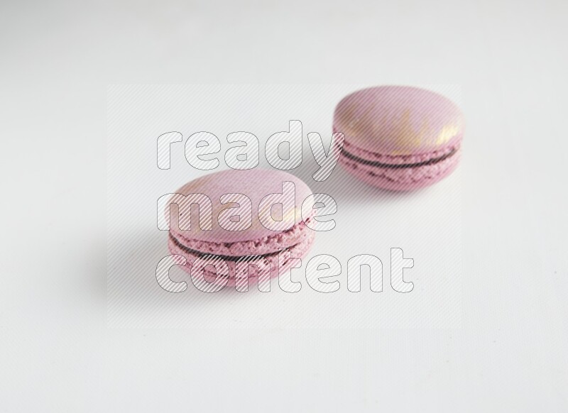 45º Shot of two Purple Strawberry macarons on white background