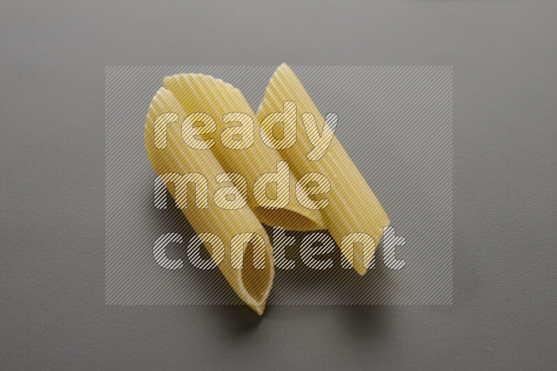 Penne pasta on grey background