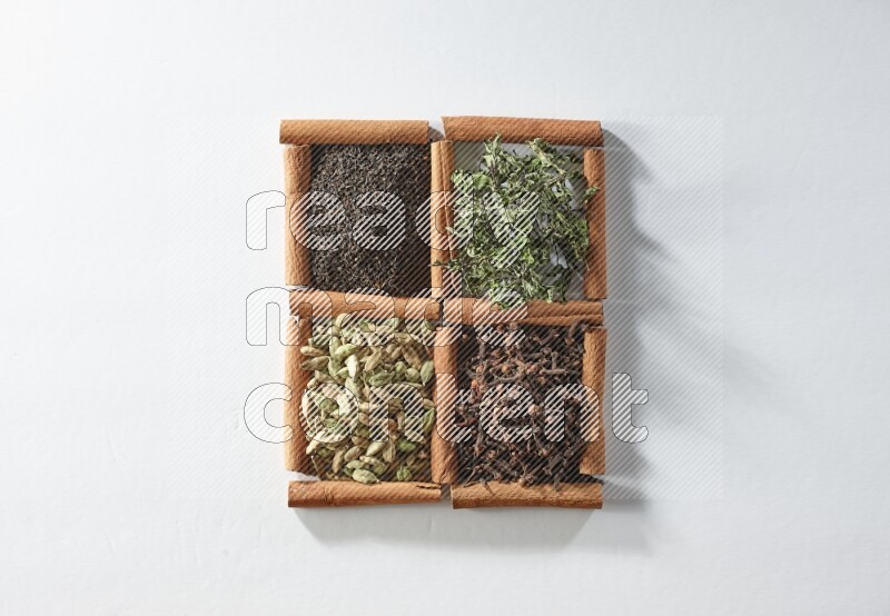 4 squares of cinnamon sticks full of tea, cardamom, mint and cloves on white flooring