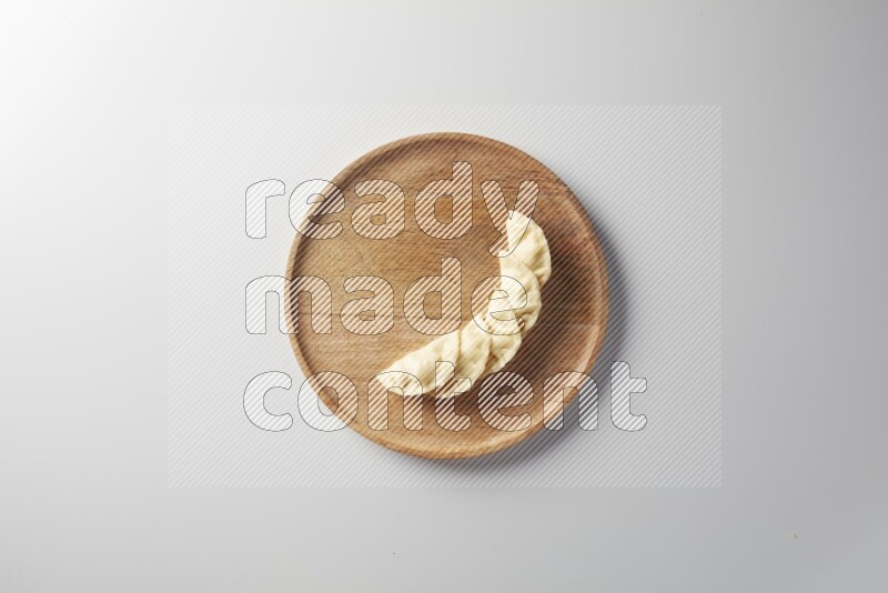 Five Sambosas on a wooden round plate on a white background