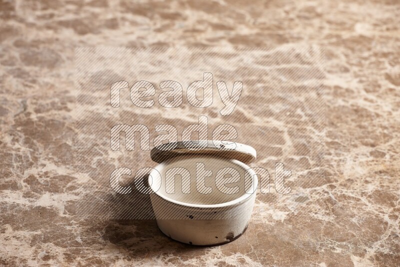 A white pottery bowl on beige marble background