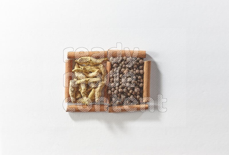 2 squares of cinnamon sticks full of allspice and turmeric fingers on white flooring