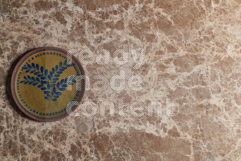 A decorative pottery plate on beige marble background