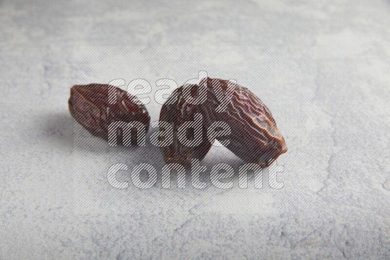 three madjoul dates on a light grey background