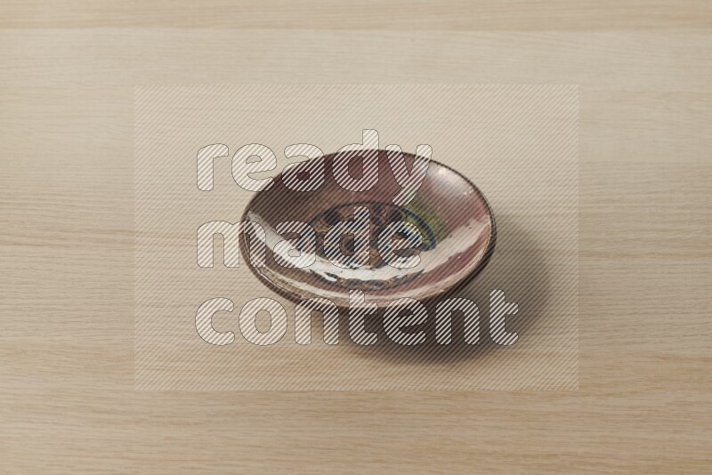 A decorative pottery plate on light wooden background