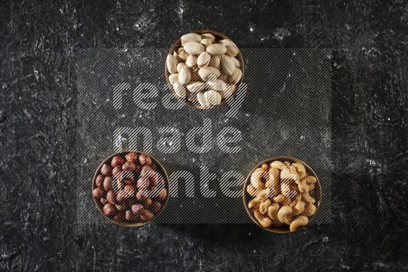 Nuts in a metal bowl in a dark setup