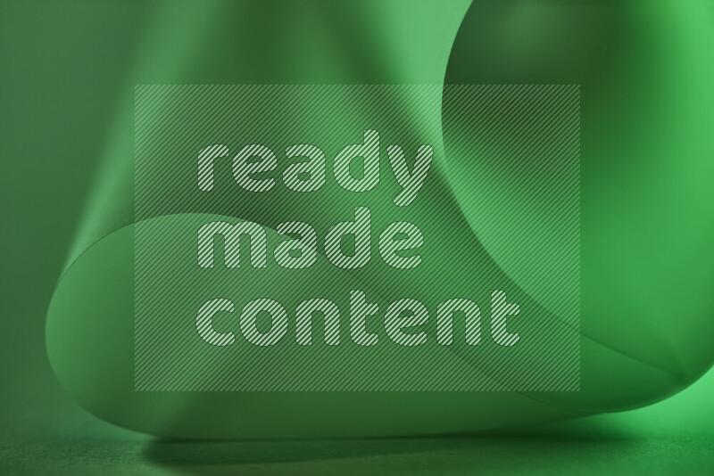 An abstract art piece displaying smooth curves in green gradients created by colored light