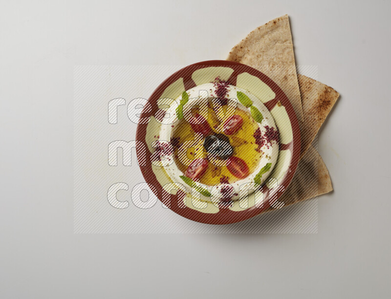 Lebnah garnished with Cherry tomato, mint & sumak  in a traditional plate on a white background