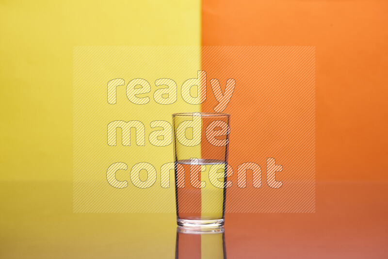 The image features a clear glassware filled with water, set against yellow and orange background