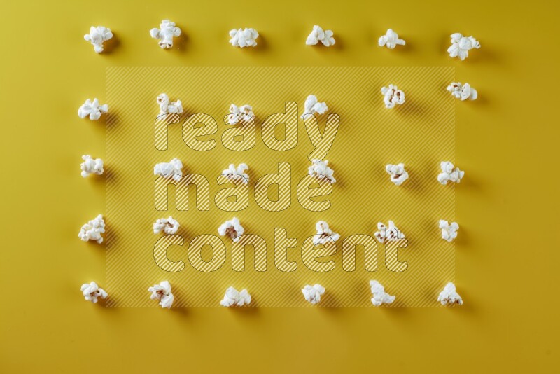 Popcorn flakes on a yellow background in different angles