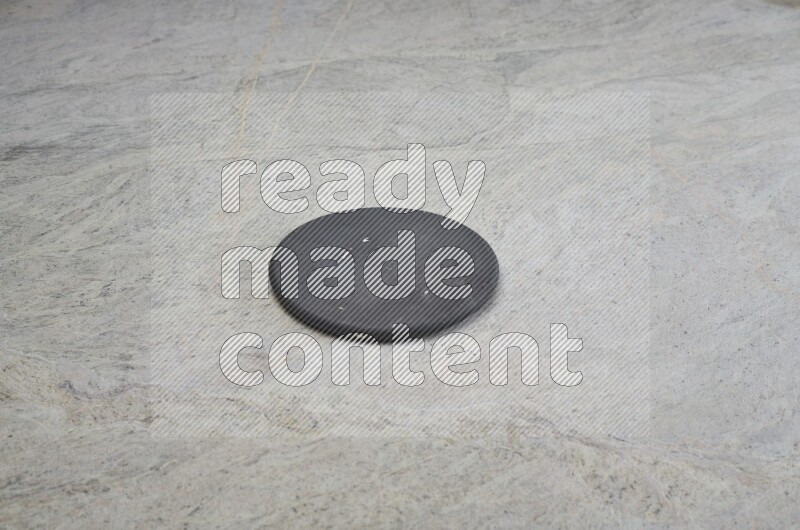 A flat pottery plate on grey marble background