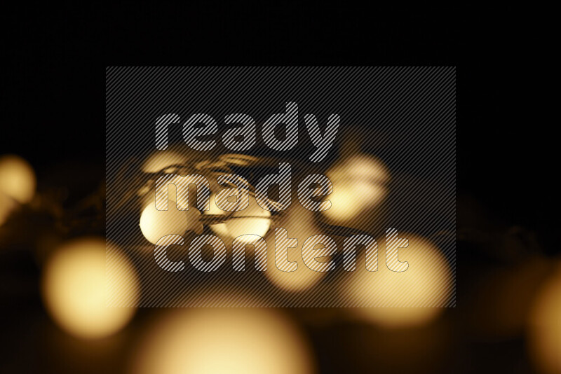 Light bulbs glowing against backdrop of golden bokeh