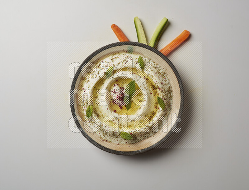 Lebnah garnished with zaater, mint & sumak in a pottery plate on a white background