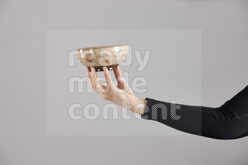 A woman in black abaya holding different pottery essentials in different positions