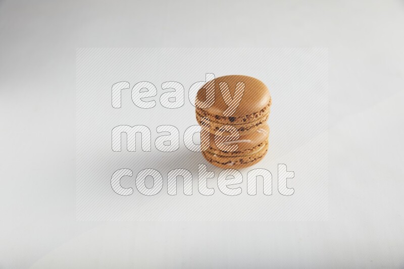 45º Shot of of two assorted Brown Irish Cream, and Brown Maple Taffy macarons  on white background
