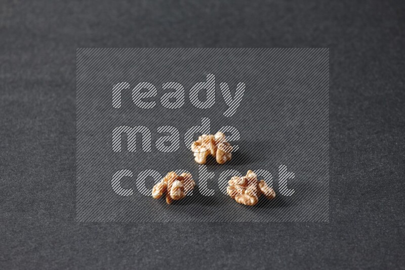 3 walnuts on a black background in different angles