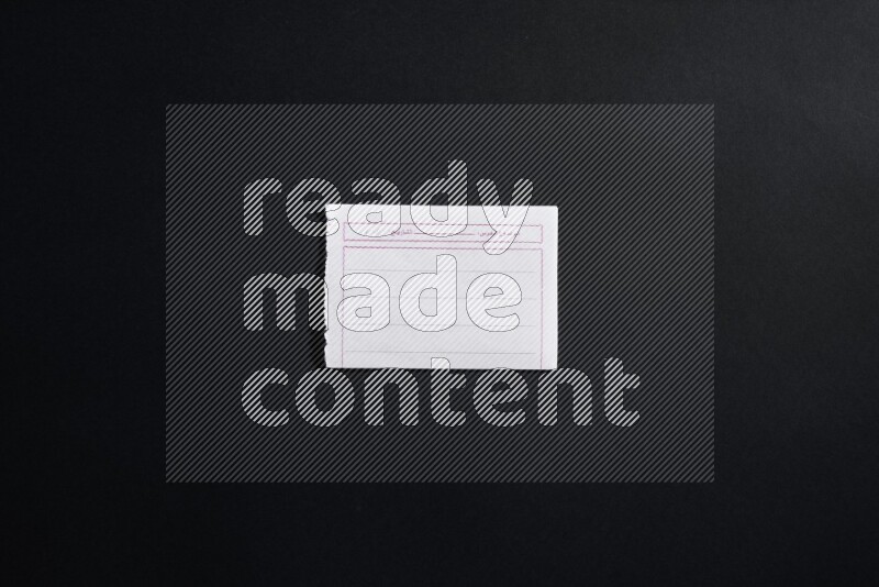 Folded notebook sheet on black background