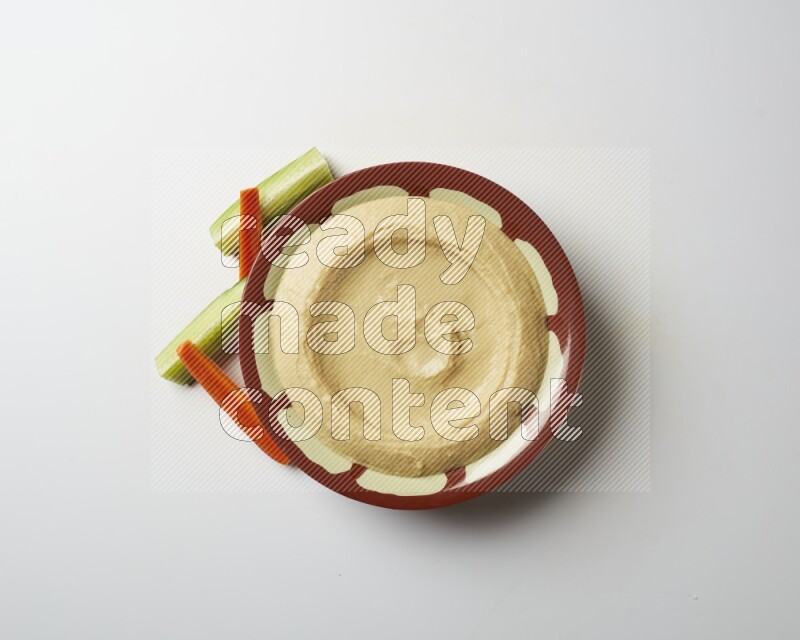 Plain hummus in a traditional plate on a white background