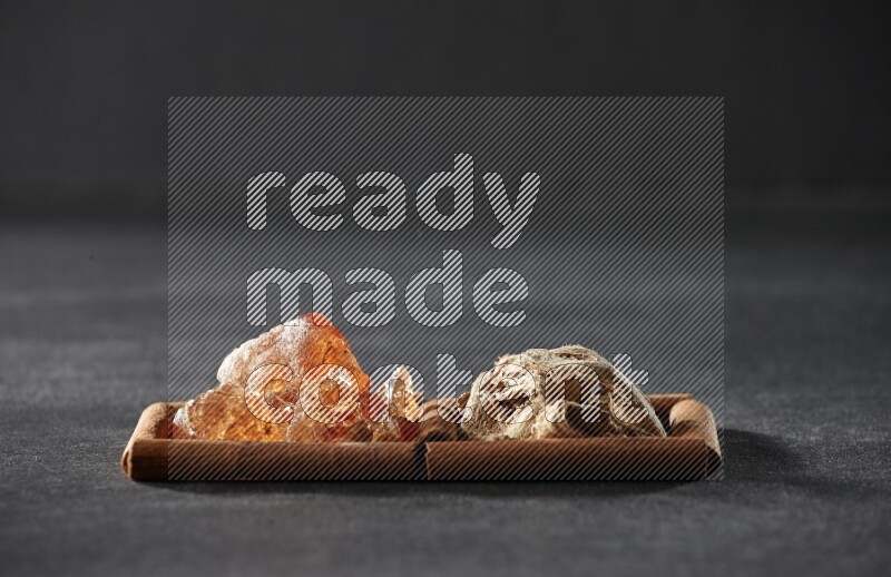 مربعان من أعواد القرفة ممتلئان بالزنجبيل المجفف والصمغ العربي علي خلفية سوداء