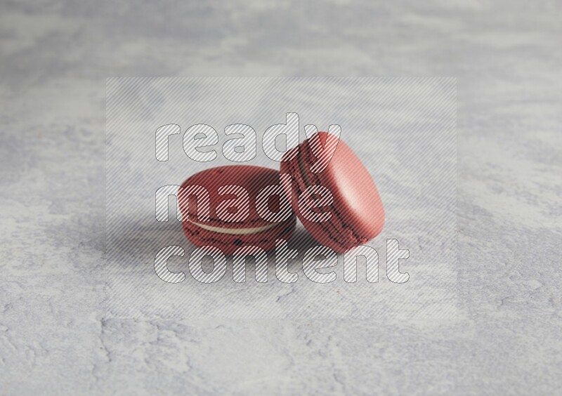 45º Shot of two Red Velvet macarons  on white  marble background