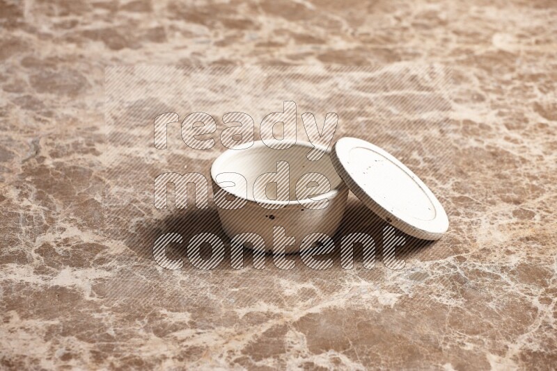 A white pottery bowl on beige marble background
