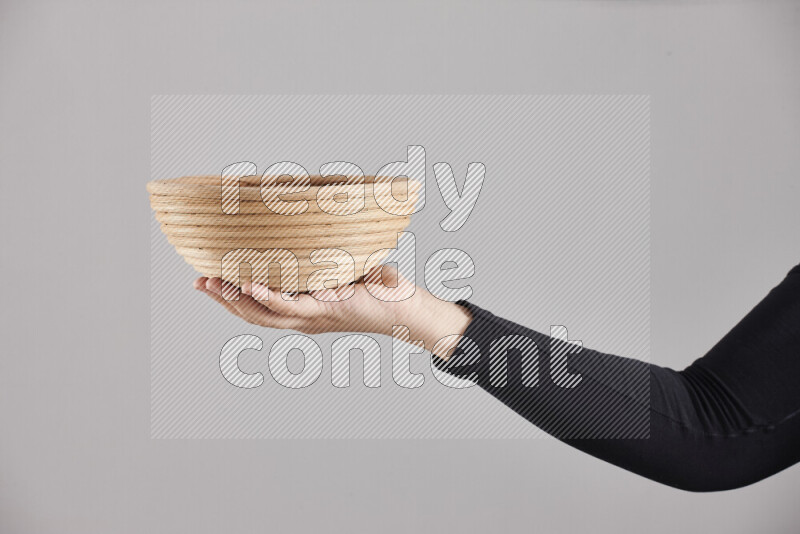 A woman in black abaya holding different wooden essentials in different positions